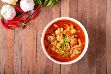 Thai curry red soup,Thailand tradition menu,boiled red curry with coconut milk and chicken on wood table.Top view