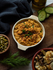Rustic carrot hummus on wooden board.