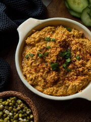 Rustic carrot hummus on wooden board.