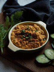 Rustic carrot hummus on wooden board.