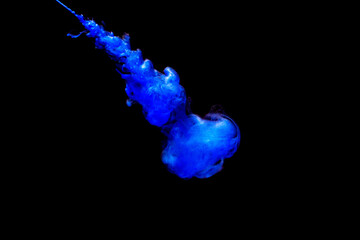 A cloud of blue paint released into clear water. Isolate on a black background.