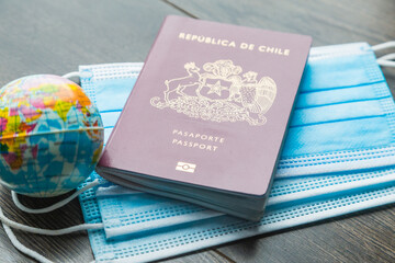 a top view of a red passport and world above some blue masks