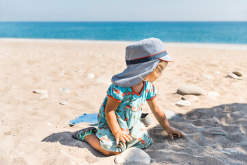 Fototapeta na wymiar Toddler girl playing on beach