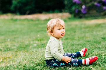 Portrait of cute baby sitting on grass