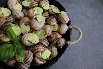 Escargots de Bourgogne. Snails prepared for cooking with garlic, butter and basil. French traditional food. Top view. Copy space. Close up.
