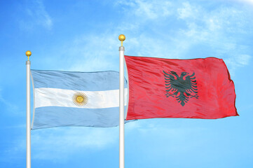 Argentina and Albania two flags on flagpoles and blue sky