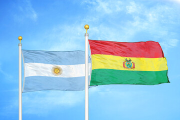Argentina and Bolivia two flags on flagpoles and blue sky