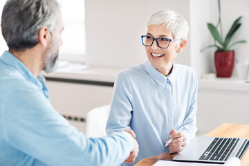 business woman office hand shaking meeting agreement handshake senior elderly success contract