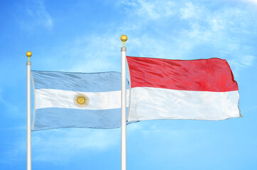 Argentina and Indonesia two flags on flagpoles and blue sky