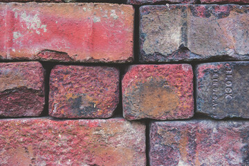 Close-up image of a pile of bright red bricks.