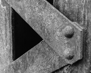 Black and white train trestle support close-up with texture.