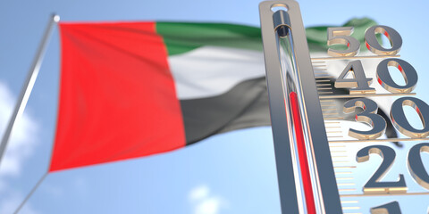 Thermometer shows high air temperature against blurred flag of the United Arab Emirates. Hot weather forecast related 3D rendering