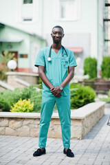 Portrait of African male doctor with stethoscope wearing green coat.