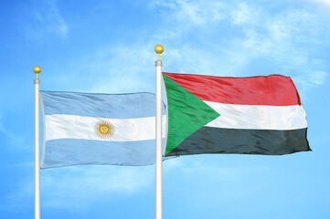 Argentina and Sudan two flags on flagpoles and blue sky