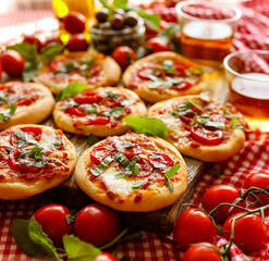 Small homemade pizzas with cherry tomatoes and mozzarella cheese sprinkled with fresh basil