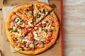 Meat pepper pizza lies on cardboard packaging