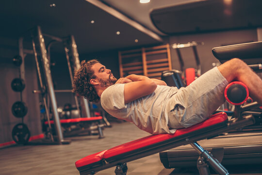 Man doing incline bench sit ups