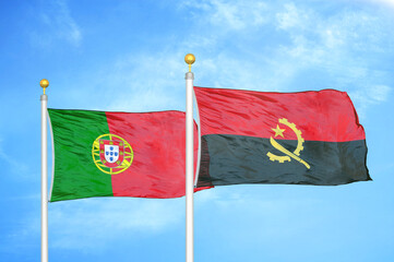 Portugal and Angola two flags on flagpoles and blue sky