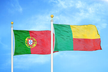 Portugal and Benin two flags on flagpoles and blue sky