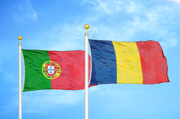 Portugal and Chad two flags on flagpoles and blue sky