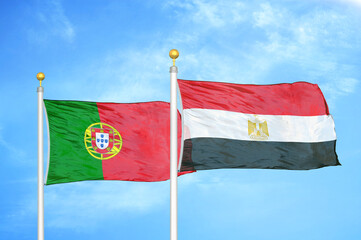 Portugal and Egypt two flags on flagpoles and blue sky