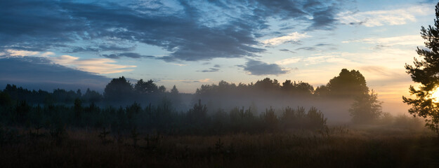 Sunrise over the fogy fields and forest, panorama, countryside, Poland, Europe