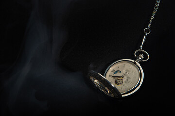 Obraz na płótnie Canvas Watch vintage pocket with smoke on black background.