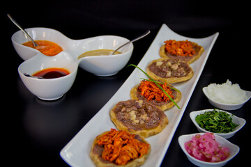 Corn tortilla snack with black beans and hot sauce