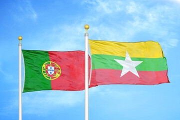 Naklejka na ściany i meble Portugal and Myanmar two flags on flagpoles and blue sky