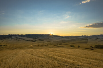 Fototapeta na wymiar First rays of summer sunrise over Pienza, Val d'Orcia, Tuscany, Italy