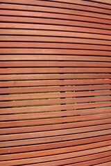 Wall texture of smooth dark brown natural wooden laths. Surface of wooden slatted screen for abstract background. Wooden slats shield.