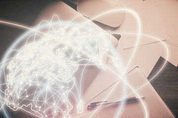 Double exposure of business theme hologram over desktop with phone. Top view. Mobile international trade connection concept.