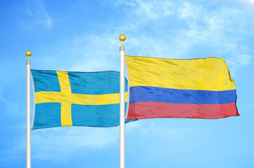 Sweden and Colombia two flags on flagpoles and blue sky