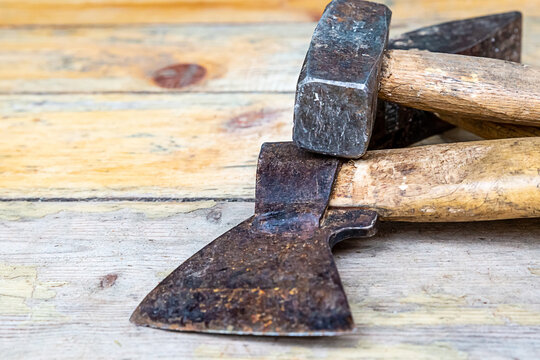 old iron ax hammer closeup lies on a wooden background building a house
