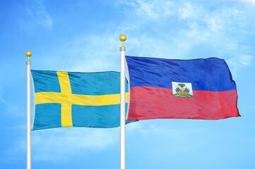Sweden and Haiti two flags on flagpoles and blue sky