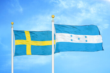 Sweden and Honduras two flags on flagpoles and blue sky