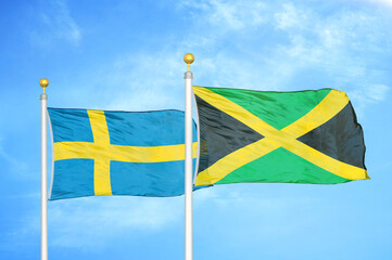 Sweden and Jamaica two flags on flagpoles and blue sky