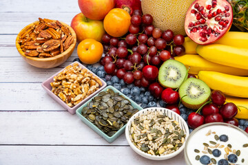 Group Nuts dry put on the bowl and fruit is banana,pineapple and grape is food healthy on the wooden table background