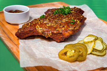 Close up board with pork ribs grilled with BBQ sauce, peanuts and jalapeno