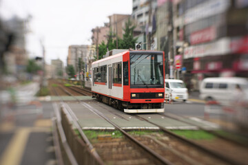 Obraz premium Tokyo,Japan-July 30, 2020: A tram car passing Machiya station rail crossing in Tokyo, Japan 