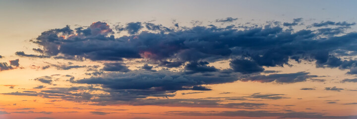 Naklejka na ściany i meble Dramatic panoramic skyscape with dark stormy clouds during sunrise