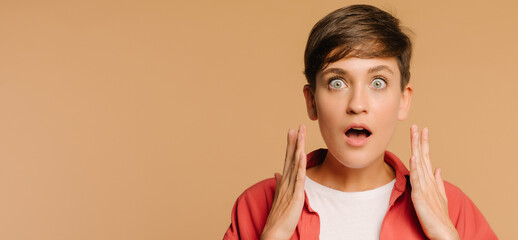  close-up portrait of a surprised girl. beige background in a photo studio