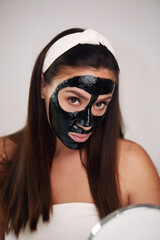 happy woman hoop on her head apply cleansing mask on face