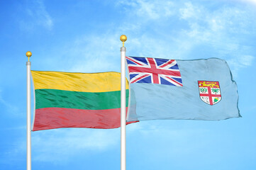Lithuania and Fiji two flags on flagpoles and blue sky