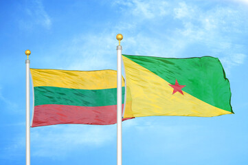 Lithuania and French Guiana two flags on flagpoles and blue sky