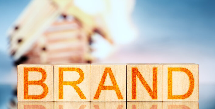 brand. wooden blocks with the inscription brand on the background of a burning match house. business crash concept - Powered by Adobe