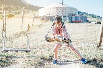 boy having fun and playing on the swing