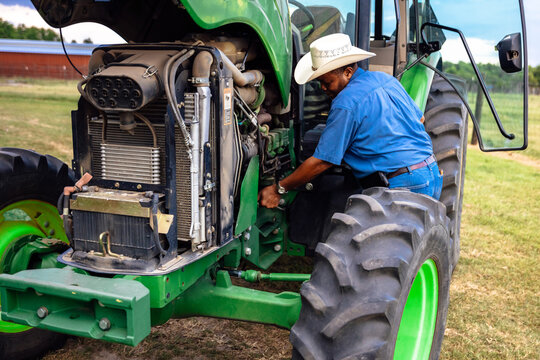 Portrait of mature man and tractor on farm