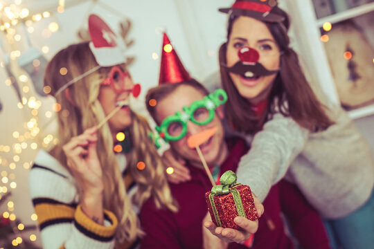 young friends celebrate christmas party with photo booth 