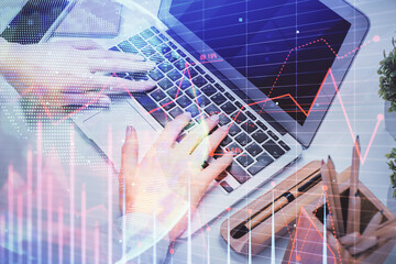 Multi exposure of woman hands typing on computer and forex chart hologram drawing. Stock market analysis concept.